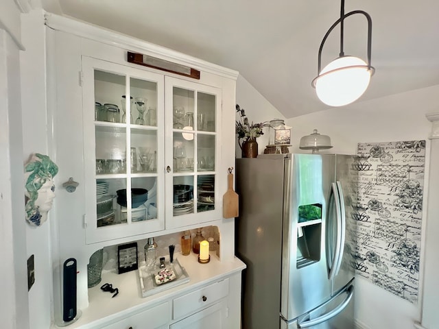 2453 Sand Hill Dr, Cape Charles, VA 23310 - kitchen featuring stainless steel refrigerator with ice dispenser, white cabinetry, glass insert cabinets, vaulted ceiling, and light countertops