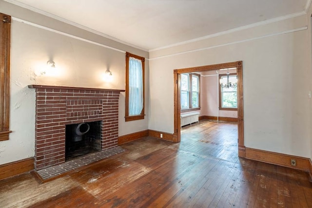 205 Monroe Ave, Cape Charles, VA 23310 - unfurnished living room with radiator, a brick fireplace, wood-type flooring, ornamental molding, and baseboards