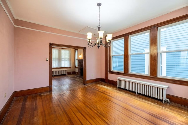 205 Monroe Ave, Cape Charles, VA 23310 - unfurnished room featuring radiator heating unit, a chandelier, baseboards, wood-type flooring, and ornamental molding