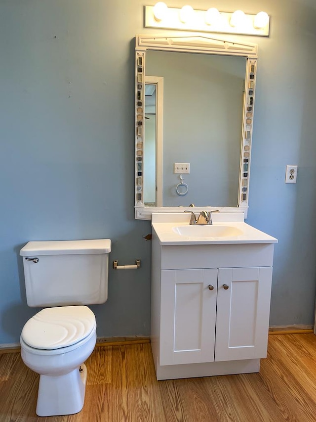 bathroom featuring vanity, wood-type flooring, and toilet