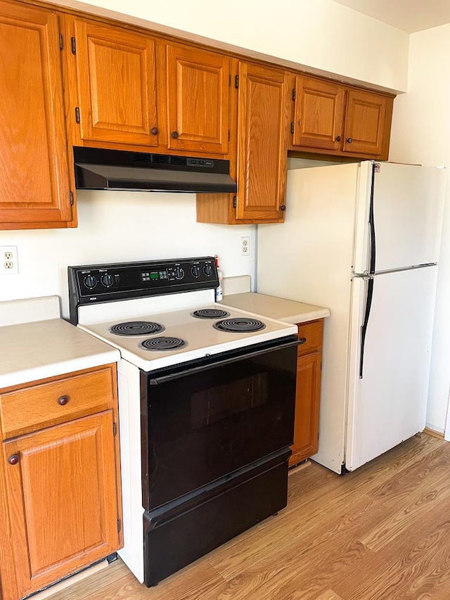 kitchen with white appliances and light hardwood / wood-style floors