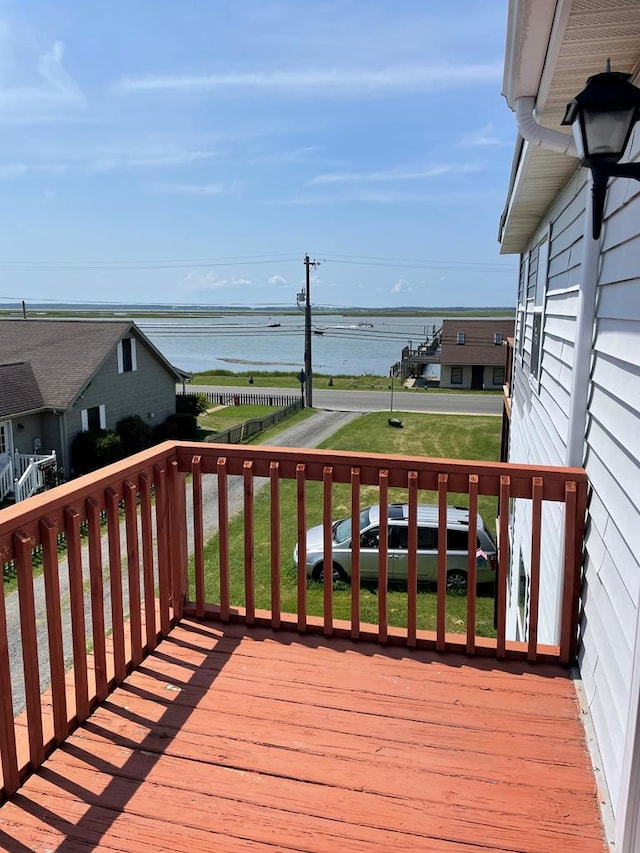 deck with a yard and a water view