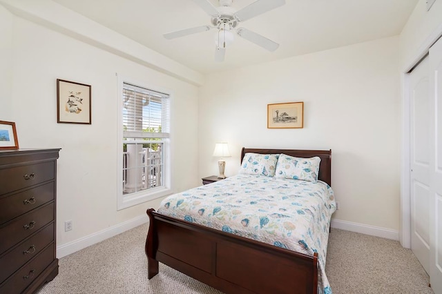 bedroom featuring ceiling fan, light colored carpet, and a closet