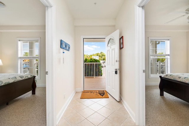 foyer with light tile patterned floors, a wealth of natural light, and ceiling fan