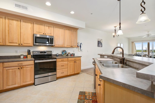 kitchen with stainless steel appliances, ceiling fan, sink, light tile patterned floors, and hanging light fixtures