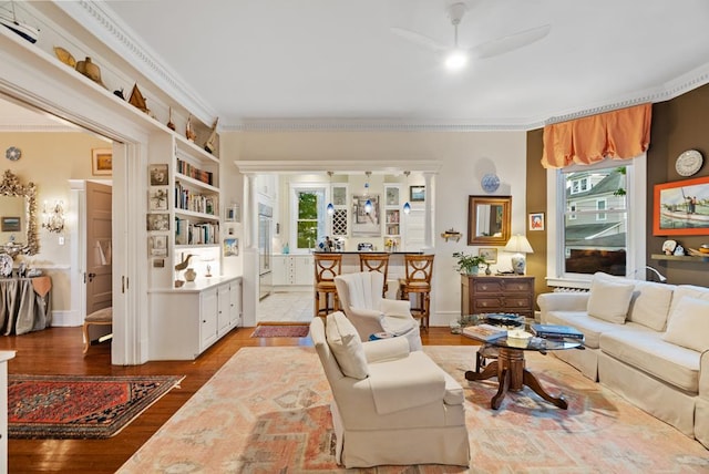 306 Bay Ave, Cape Charles, VA 23310 - living area with a ceiling fan, healthy amount of natural light, crown molding, wood finished floors, and built in shelves