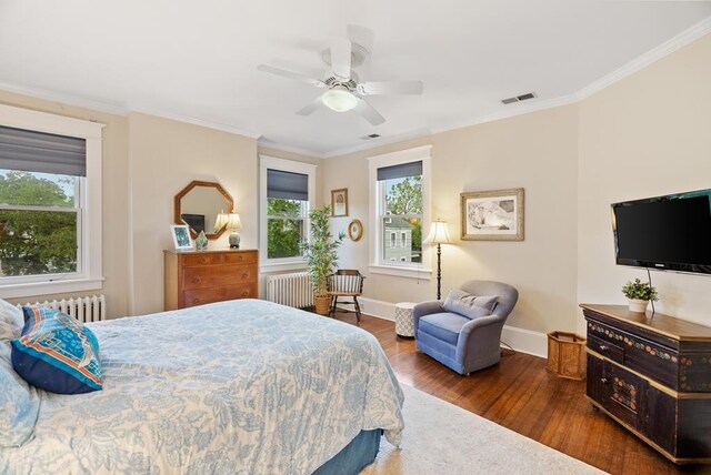 306 Bay Ave, Cape Charles, VA 23310 - bedroom featuring radiator heating unit, wood finished floors, multiple windows, and crown molding