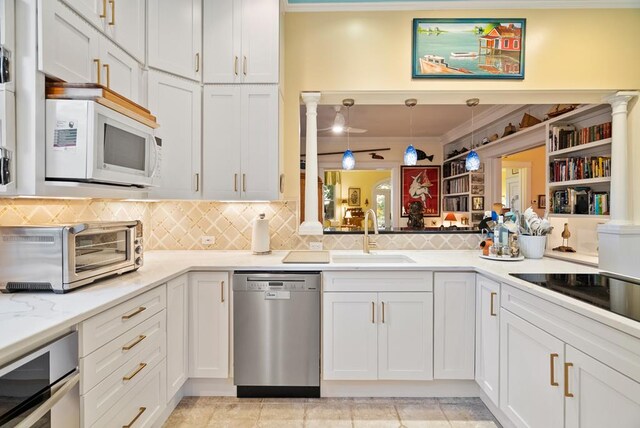 306 Bay Ave, Cape Charles, VA 23310 - kitchen featuring stainless steel appliances, a sink, backsplash, white cabinetry, and crown molding