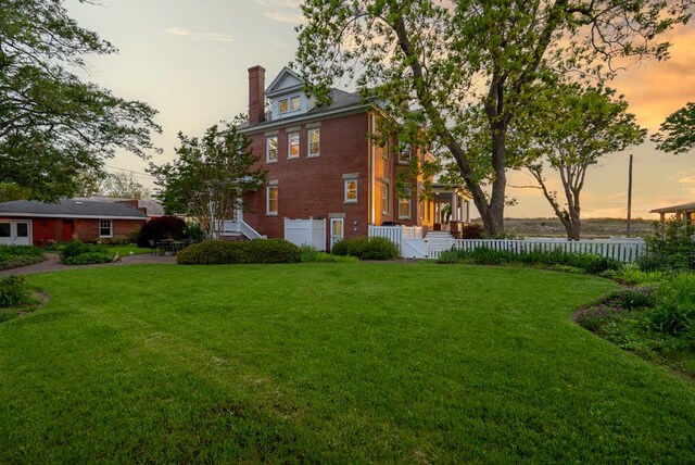 306 Bay Ave, Cape Charles, VA 23310 - property exterior at dusk featuring brick siding and a chimney