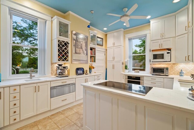 306 Bay Ave, Cape Charles, VA 23310 - kitchen with a warming drawer, white microwave, a sink, tasteful backsplash, and ornamental molding