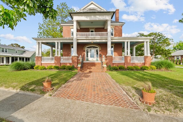 306 Bay Ave, Cape Charles, VA 23310 - greek revival house featuring a porch, brick siding, and a front lawn