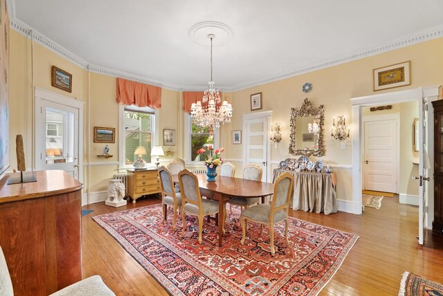 306 Bay Ave, Cape Charles, VA 23310 - dining area with a chandelier, light wood finished floors, ornamental molding, and baseboards