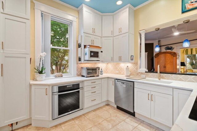 306 Bay Ave, Cape Charles, VA 23310 - kitchen featuring appliances with stainless steel finishes, a sink, tasteful backsplash, ornamental molding, and white cabinetry