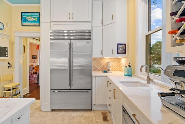 306 Bay Ave, Cape Charles, VA 23310 - kitchen featuring stainless steel built in refrigerator, a sink, white cabinets, backsplash, and ornamental molding