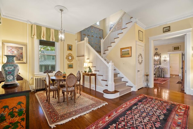 306 Bay Ave, Cape Charles, VA 23310 - dining area with radiator heating unit, wood-type flooring, stairway, baseboards, and ornamental molding