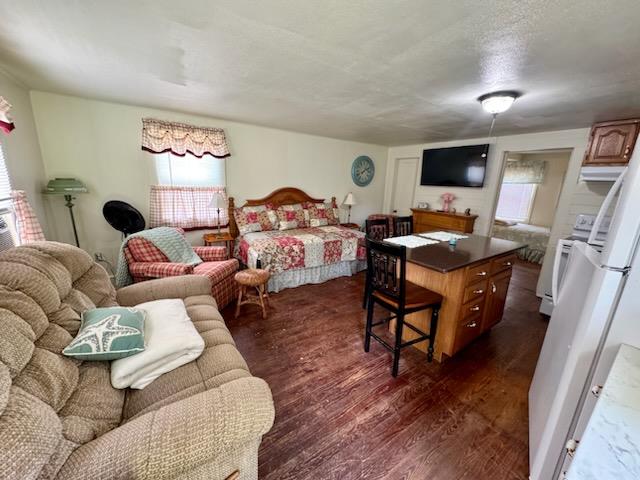 bedroom with dark hardwood / wood-style floors and a textured ceiling