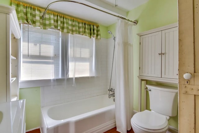 bathroom with toilet and shower / bath combo with shower curtain