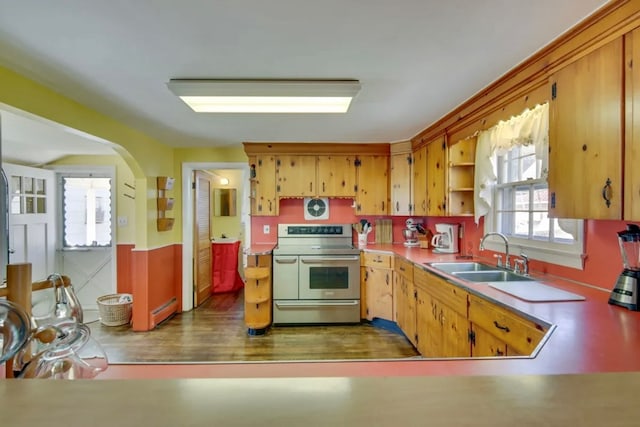 kitchen with range with two ovens, a baseboard radiator, and sink