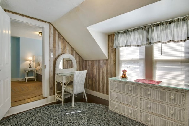 interior space featuring lofted ceiling and wooden walls