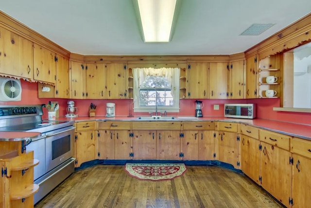 kitchen with appliances with stainless steel finishes, sink, and hardwood / wood-style floors