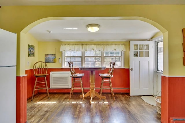 bar with dark wood-type flooring and white refrigerator