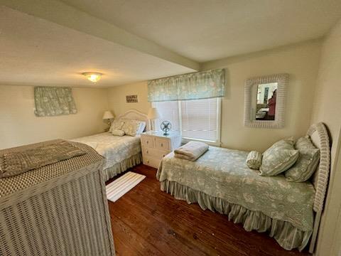 bedroom with dark wood-type flooring and beamed ceiling