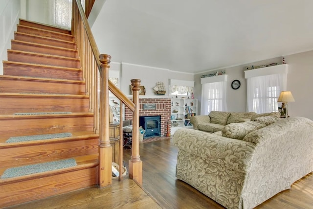 living room with a brick fireplace and hardwood / wood-style floors