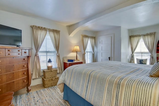 bedroom with beamed ceiling and wood-type flooring