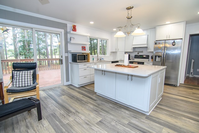 22170 Barnes Cir, Parksley, VA 23421 - kitchen with stainless steel appliances, a kitchen island, white cabinets, crown molding, and hanging light fixtures