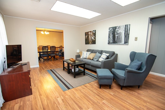 22170 Barnes Cir, Parksley, VA 23421 - living area featuring a chandelier, crown molding, light wood-type flooring, and baseboards