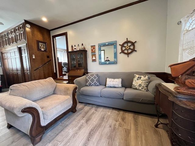 living area featuring ornamental molding and wood finished floors