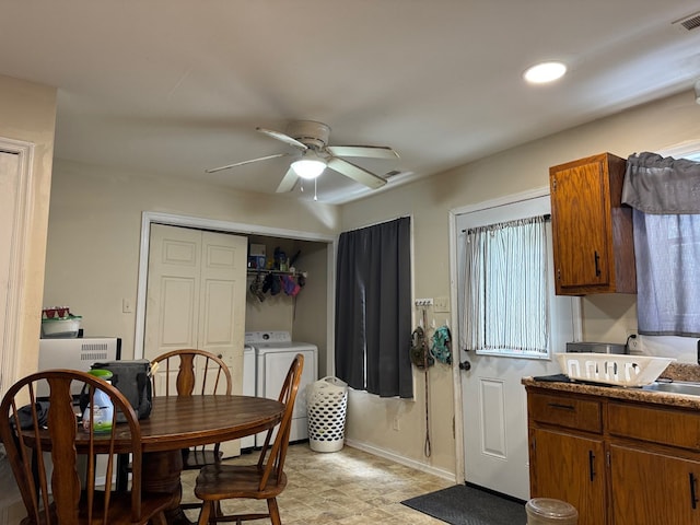 dining space featuring washer and dryer, ceiling fan, and sink