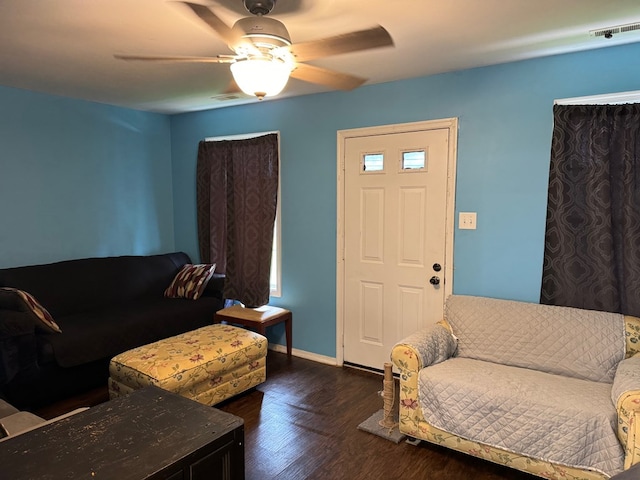 living room with ceiling fan and dark wood-type flooring