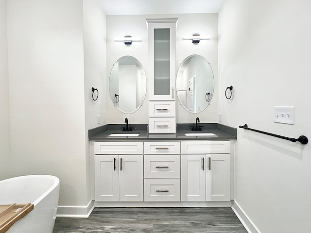 27212 Castle Row, Cape Charles, VA 23310 - bathroom featuring double vanity, a soaking tub, and wood finished floors