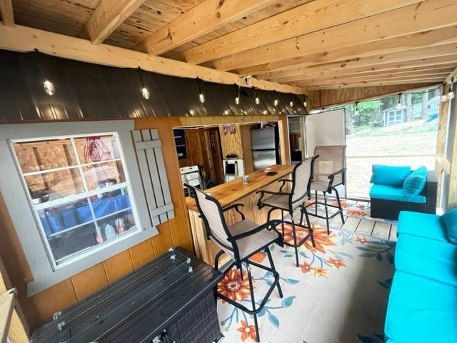 sunroom / solarium featuring wooden ceiling and lofted ceiling