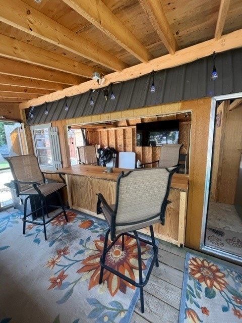 interior space featuring beamed ceiling and wooden walls