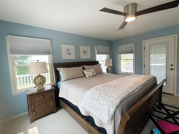 5061 Bay Colony Ln, Chincoteague, VA 23336 - bedroom with light colored carpet, multiple windows, and baseboards