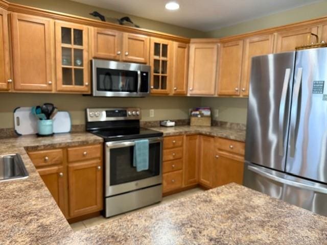 5061 Bay Colony Ln, Chincoteague, VA 23336 - kitchen featuring stainless steel appliances, recessed lighting, glass insert cabinets, a sink, and light stone countertops