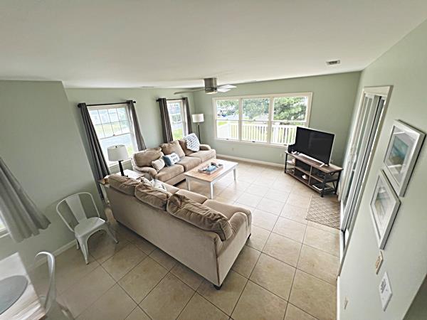 5061 Bay Colony Ln, Chincoteague, VA 23336 - living room with light tile patterned floors and baseboards