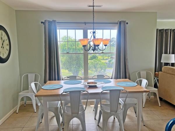 5061 Bay Colony Ln, Chincoteague, VA 23336 - dining area with light tile patterned floors, a chandelier, and baseboards