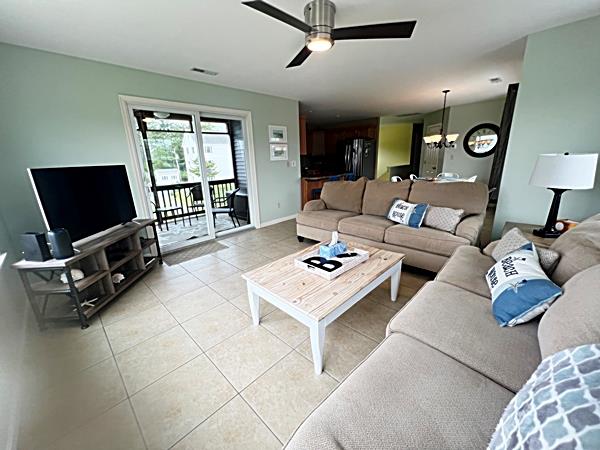 5061 Bay Colony Ln, Chincoteague, VA 23336 - living area featuring light tile patterned floors, ceiling fan, a chandelier, and baseboards