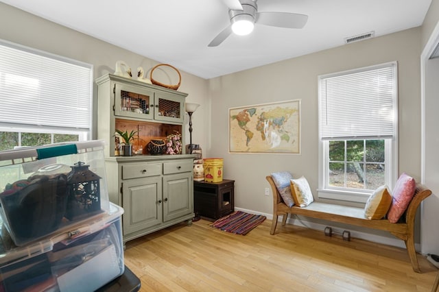 sitting room with ceiling fan and light wood-type flooring