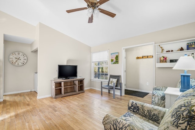 living room featuring ceiling fan, vaulted ceiling, and light wood-type flooring