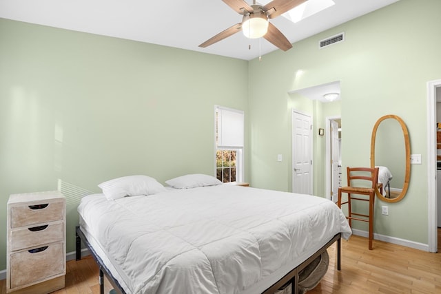 bedroom featuring light wood-type flooring, a skylight, and ceiling fan