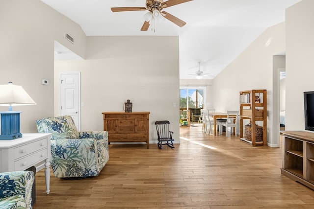 sitting room with ceiling fan, vaulted ceiling, and light hardwood / wood-style flooring