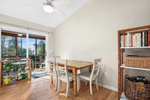 dining space with ceiling fan, vaulted ceiling, and light wood-type flooring