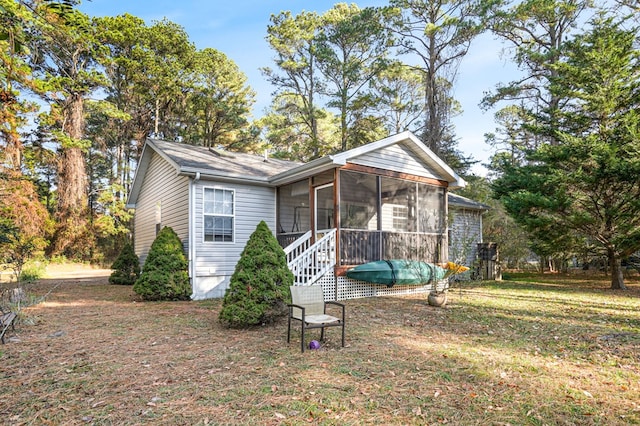 view of front facade featuring a sunroom and a front yard