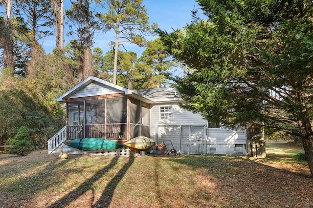 back of property featuring a lawn and a sunroom