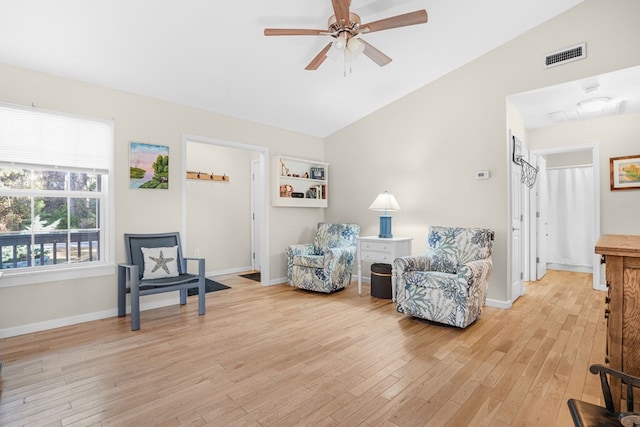 living area with ceiling fan, vaulted ceiling, and light wood-type flooring