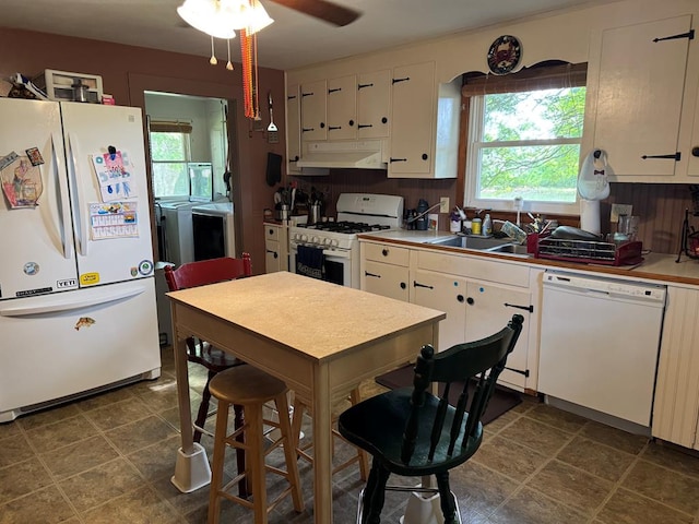 22338 Accomac Rd, Accomac, VA 23301 - kitchen featuring white appliances, under cabinet range hood, washer and clothes dryer, a sink, and white cabinets
